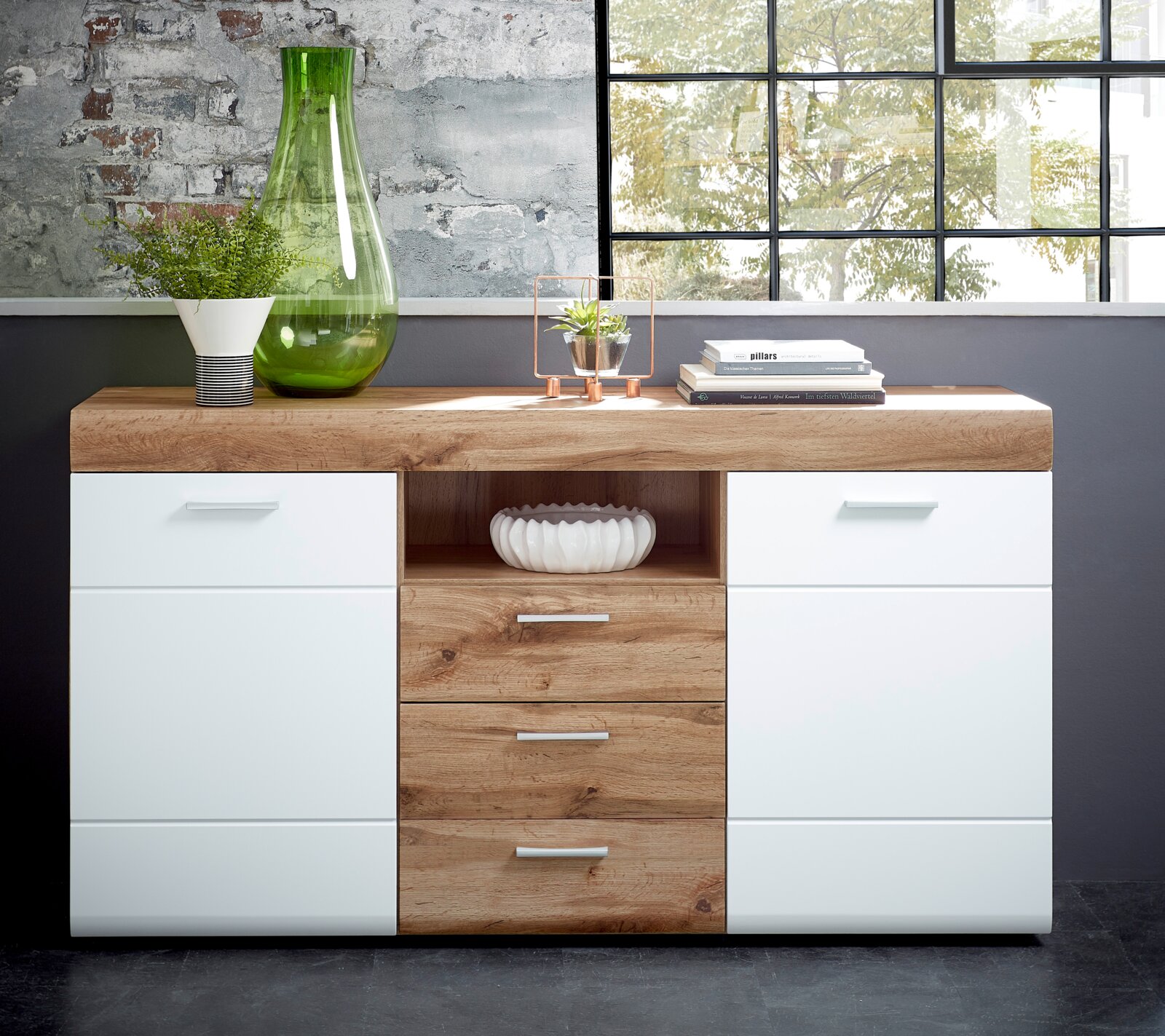 XORA Dressoir LYON Modernes Sideboard aus Holz und Weiß mit Schubladen und Regalfächern, dekoriert mit Pflanzen und Büchern, aus frontaler Perspektive.