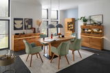 Esszimmer mit modernem Highboard aus Holz, umgeben von grünen Stühlen und dekorativen Elementen, seitliche Perspektive