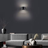 Moderne Wandleuchte PURE CLIPSE von Paul Neuhaus in einem stilvollen Wohnzimmer, frontal betrachtet.