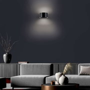 Moderne wandlamp PURE CLIPSE van Paul Neuhaus in een stijlvolle woonkamer, gezien vanaf de voorkant.