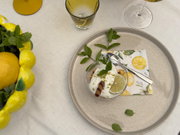 Dessert mit Limettenscheibe und Minze auf Tablett mit Zitronenserviette.