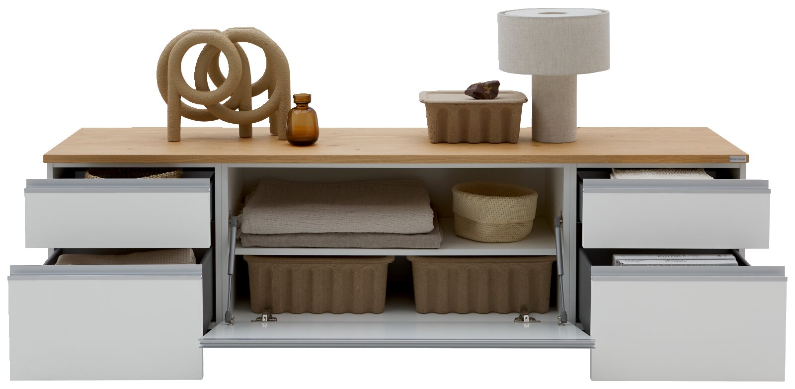 Modernes Sideboard mit heller Holzplatte und weißen Auszügen, mittlerer Klappe geöffnet und Schubladen ausgezogen, dekoriert mit Skulptur, Vase und Tischlampe; Ansicht von vorne in leicht erhöhter Perspektive.