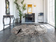 Runder Designer Teppich in einem eleganten Wohnzimmer mit klassischem Dekor, Blick von schräg oben.