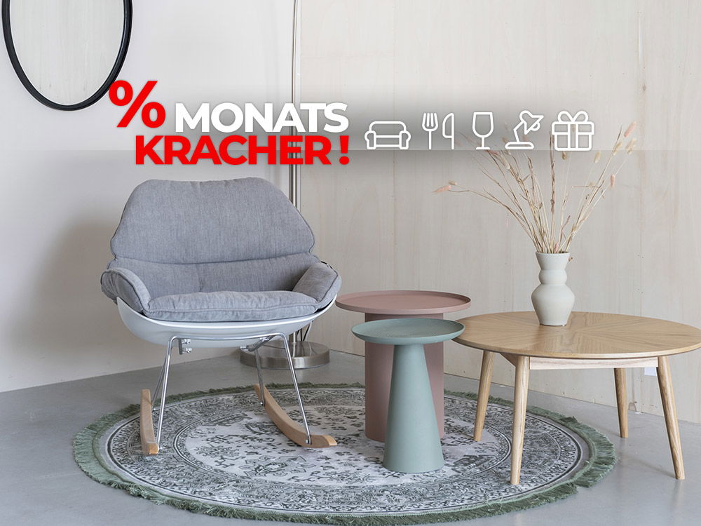 Gemütliche Sitzecke mit grauem Sessel, runden Tischen und Teppich, darüber Schriftzug „% MONATSKRACHER!