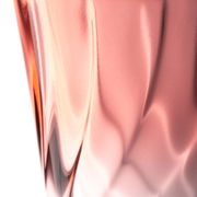 Nahaufnahme eines roten Trinkglases mit gedrehtem Design, seitliche Perspektive