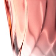 Nahaufnahme eines roten Trinkglases mit gedrehtem Design, seitliche Perspektive