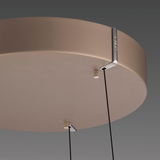 Nahaufnahme der Unterseite einer LED-Pendelleuchte mit runder, glatter Oberfläche und zwei Kabeln, die von der Decke hängen.