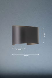 Moderne Wandleuchte in geschwungener Form, seitliche Perspektive, Maße: 18 cm Breite, 12 cm Höhe, 9,5 cm Tiefe.