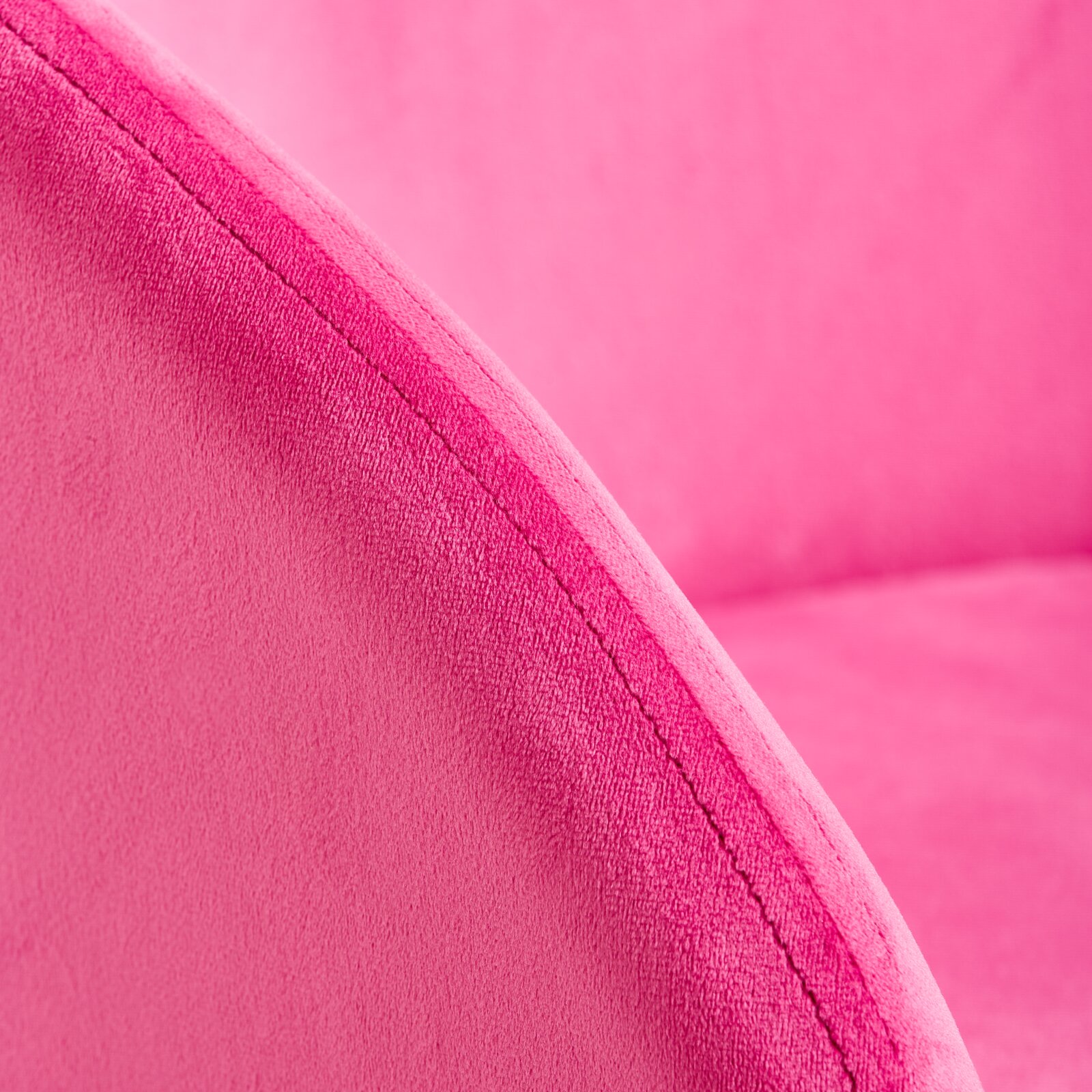 Nahaufnahme eines pinken Sessels mit weicher Polsterung, Fokus auf die Naht der Armlehne.
