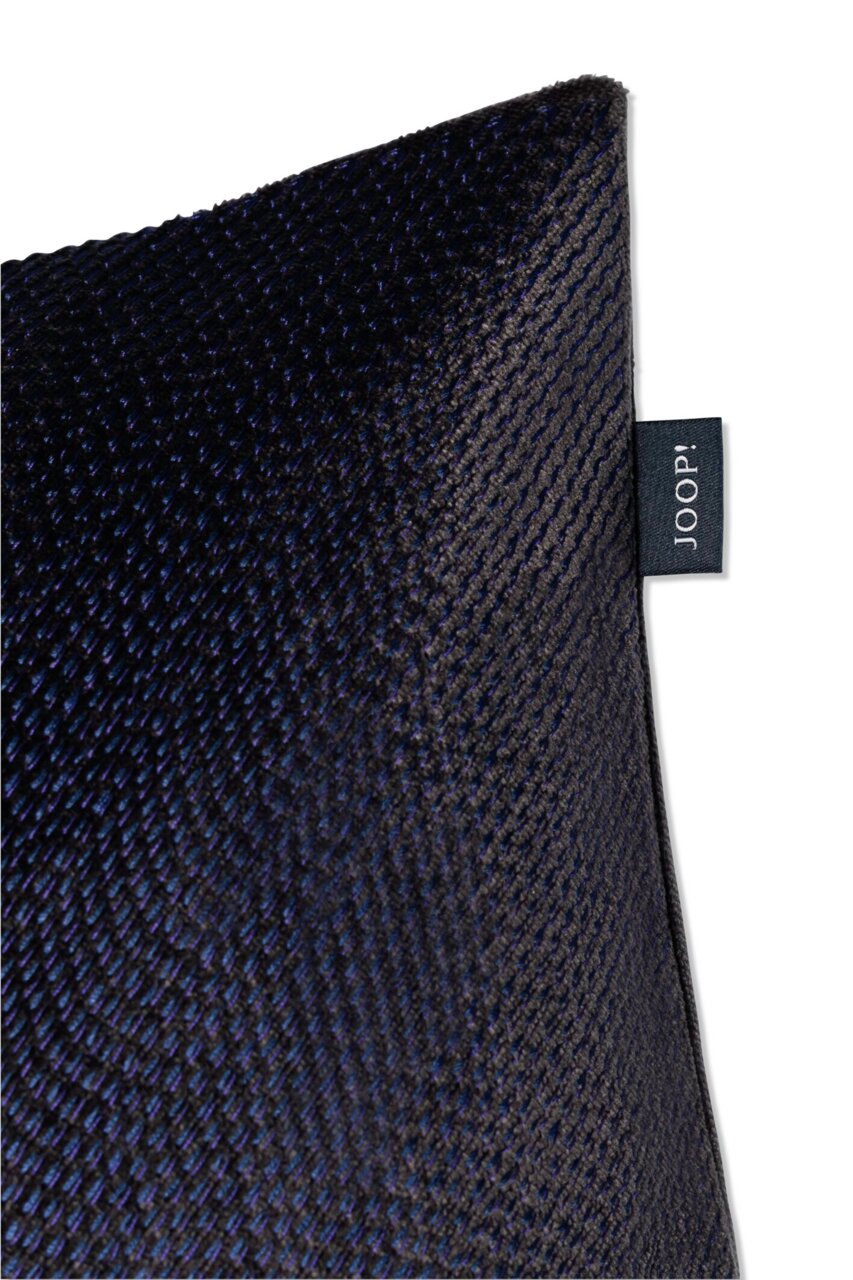 Close-up van een donkerblauwe sierkussenhoes met een fijne structuur en een JOOP!-label aan de zijkant.