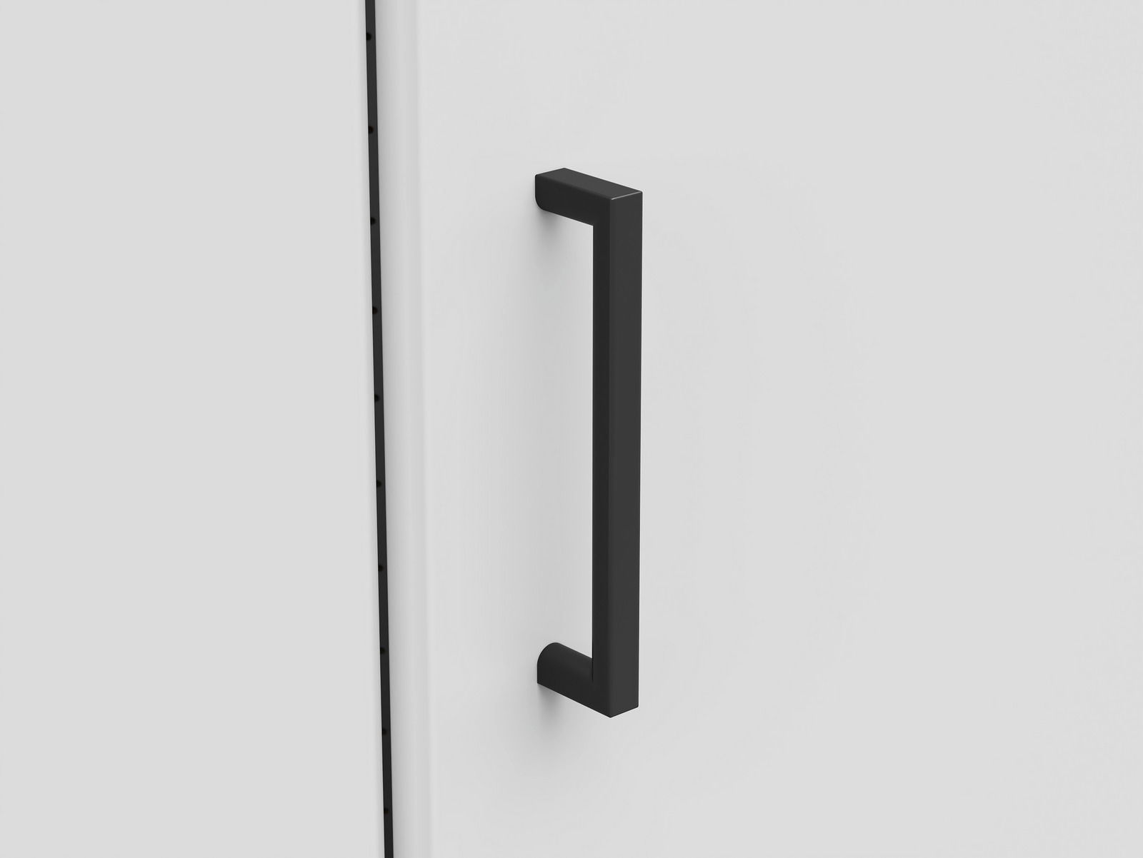 Nahaufnahme eines schwarzen Griffs an einer weißen Schranktür, seitliche Perspektive