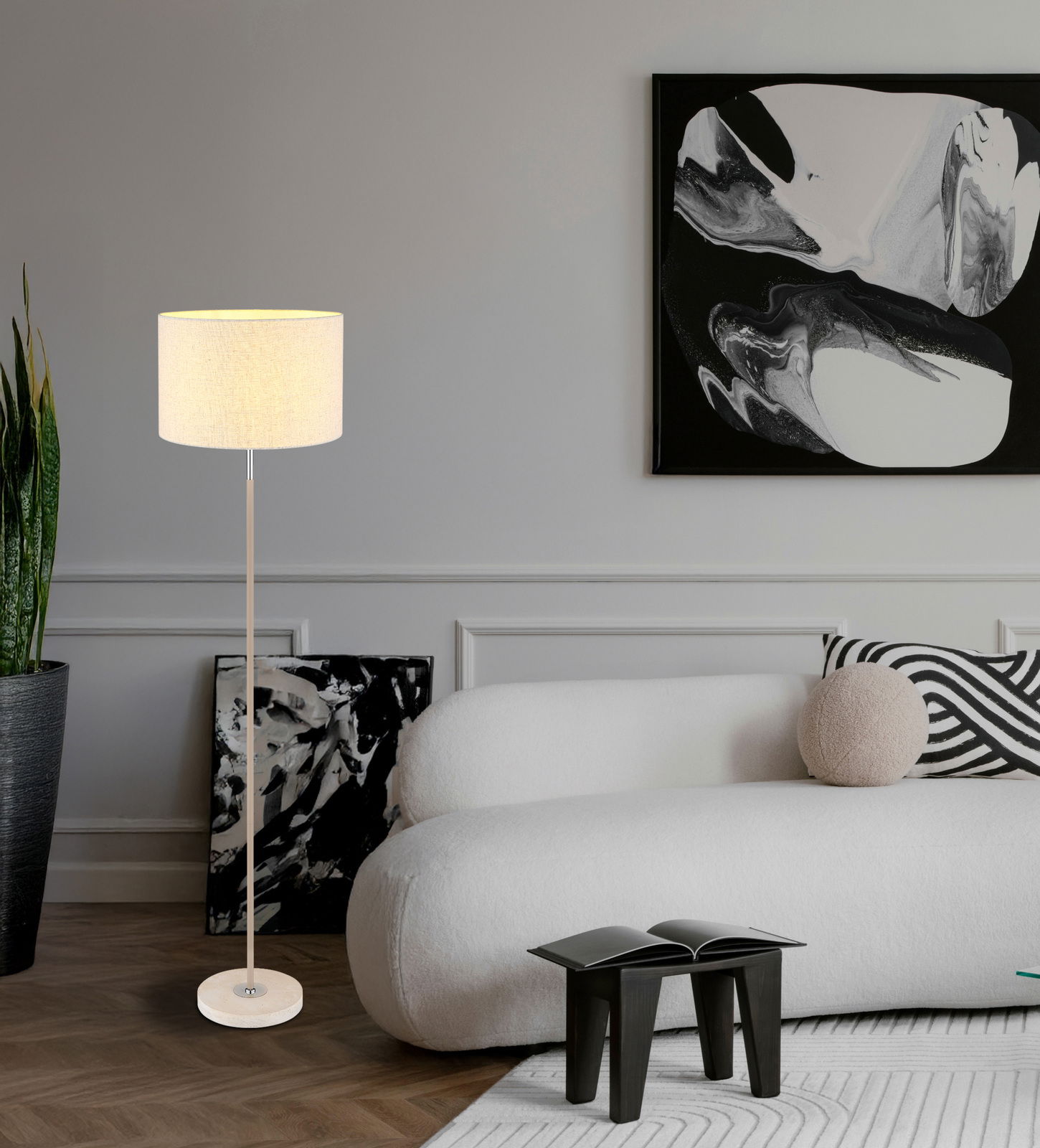 Moderne Stehleuchte mit hellem Lampenschirm in einem stilvoll eingerichteten Wohnzimmer, seitliche Perspektive.