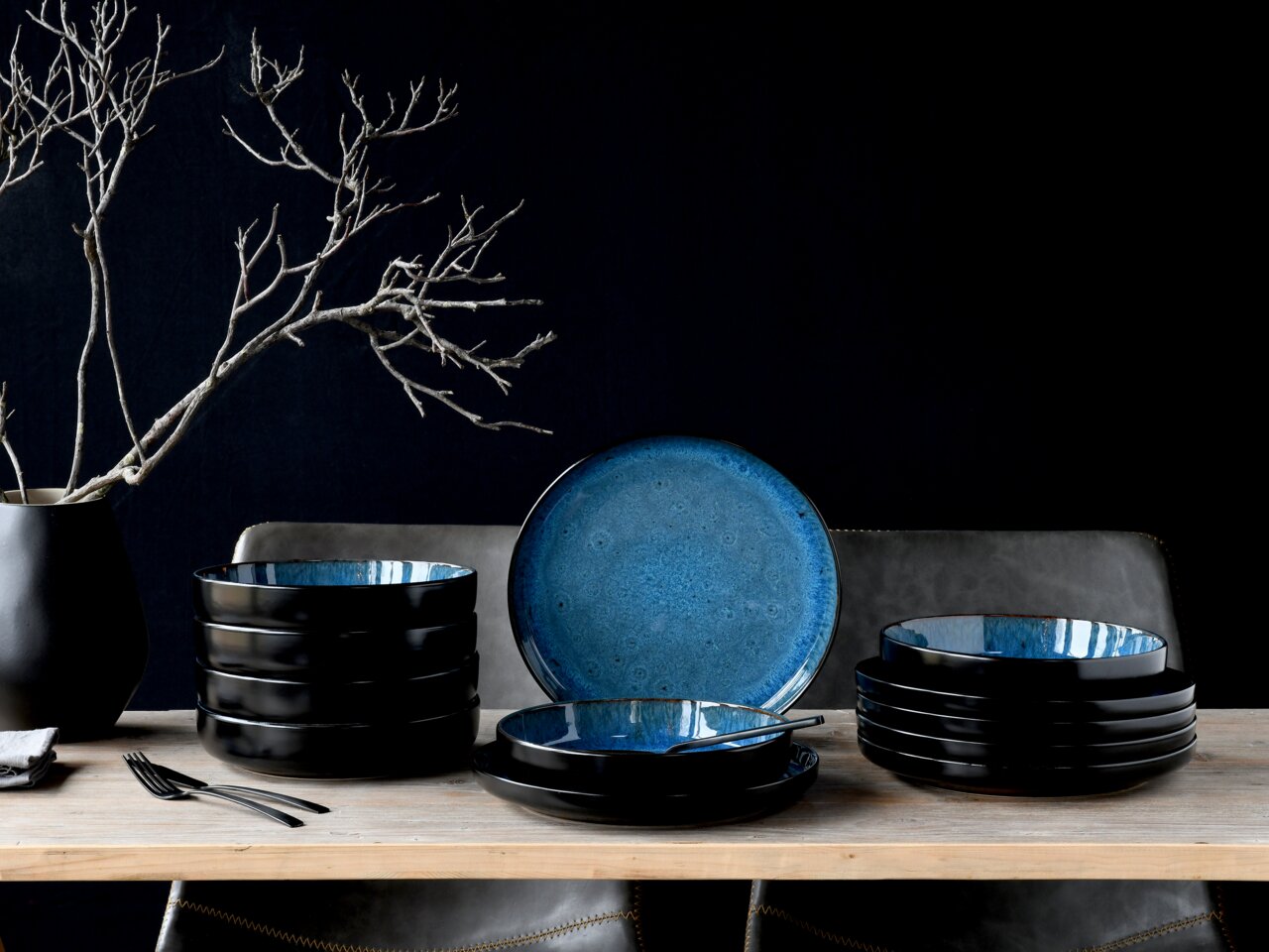 Creatable Tafelservice 12-tlg NORDIC FJORD Elegantes Tafelservice 12-tlg in Schwarz und Blau, seitliche Perspektive, auf einem Holztisch arrangiert mit dekorativem Ast im Hintergrund.