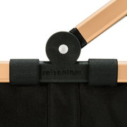Nahaufnahme des schwarzen und goldenen Rahmens eines Carrybags von reisenthel, mit Fokus auf das Scharnier.