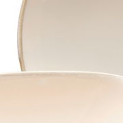 Nahaufnahme von zwei übereinanderliegenden, cremefarbenen Tellern mit leichtem Randdetail.