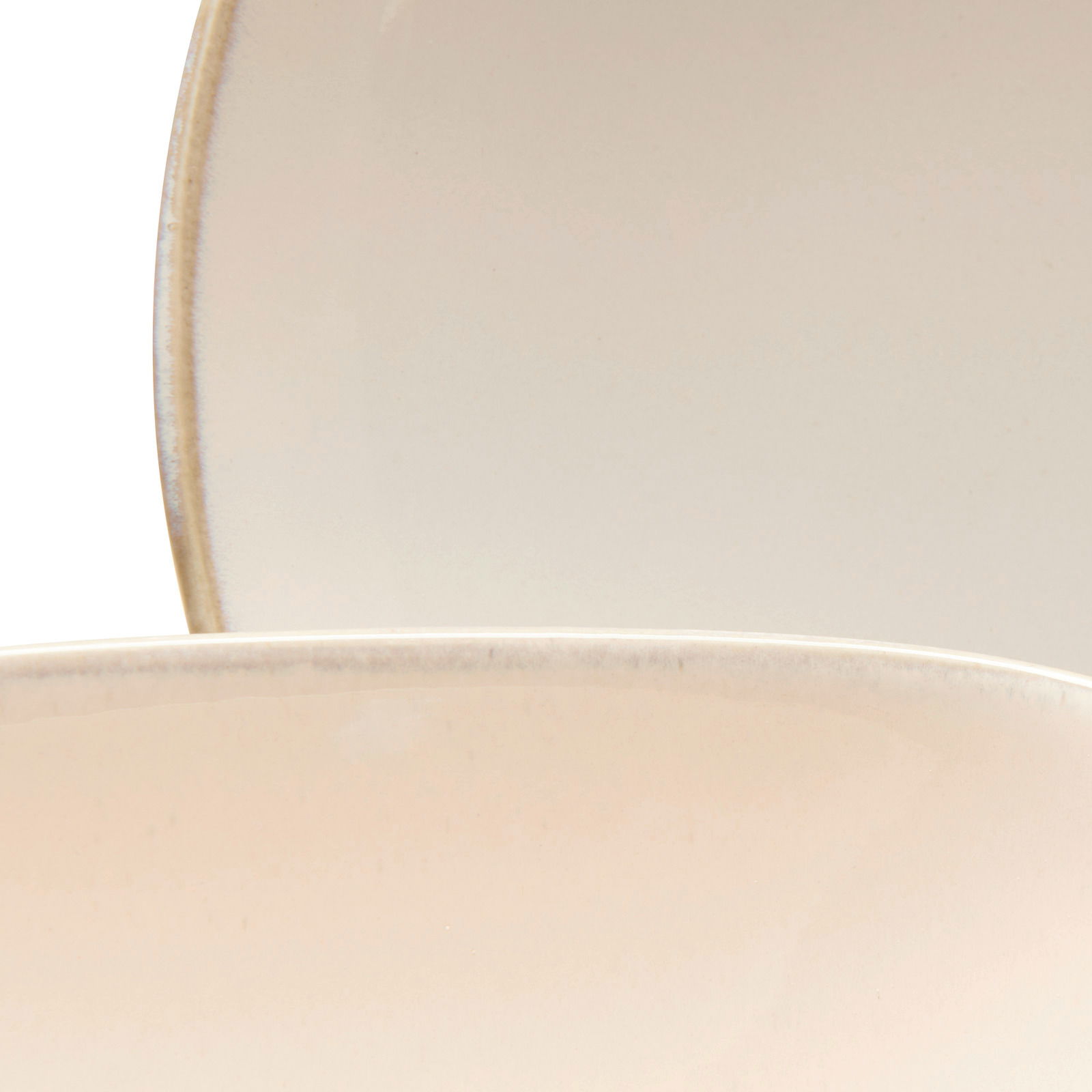 Nahaufnahme von zwei übereinanderliegenden, cremefarbenen Tellern mit leichtem Randdetail.