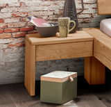 Holz-Nachtkommode mit Schublade, dekoriert mit Tasse und Schale, vor einer Ziegelwand, seitliche Perspektive