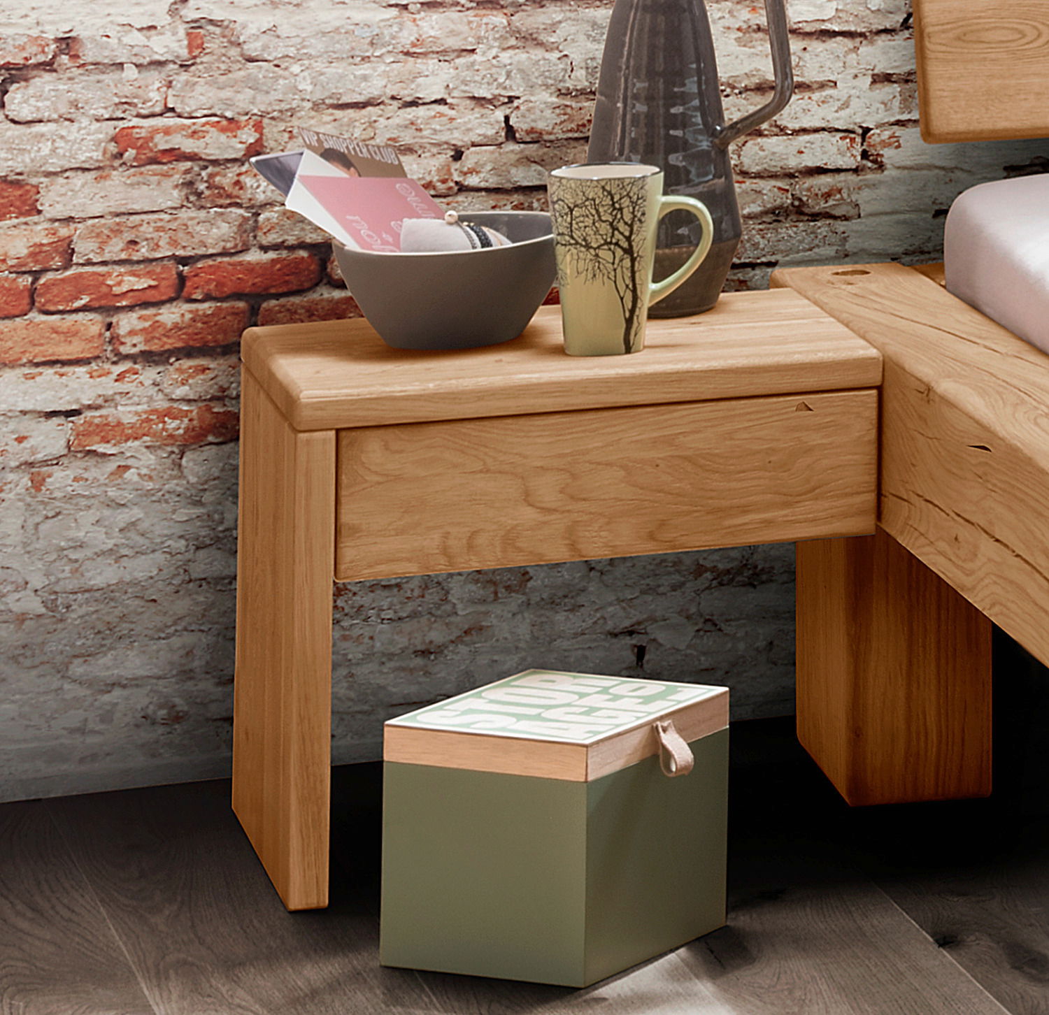 Valnatura Nachtkommode LIGNUM Holz-Nachtkommode mit Schublade, dekoriert mit Tasse und Schale, vor einer Ziegelwand, seitliche Perspektive