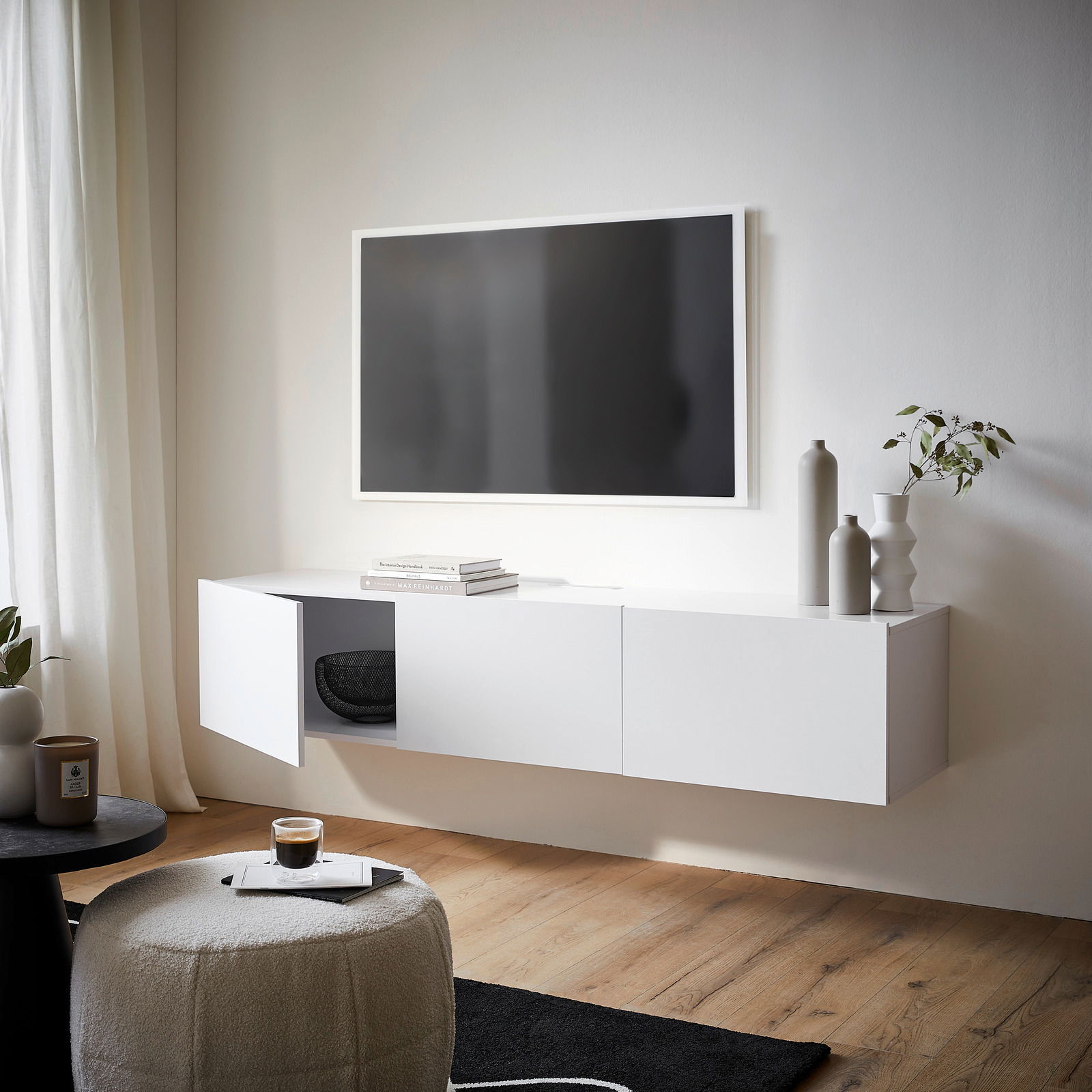 Modernes weißes TV-Hängelowboard in einem stilvollen Wohnzimmer, seitliche Perspektive