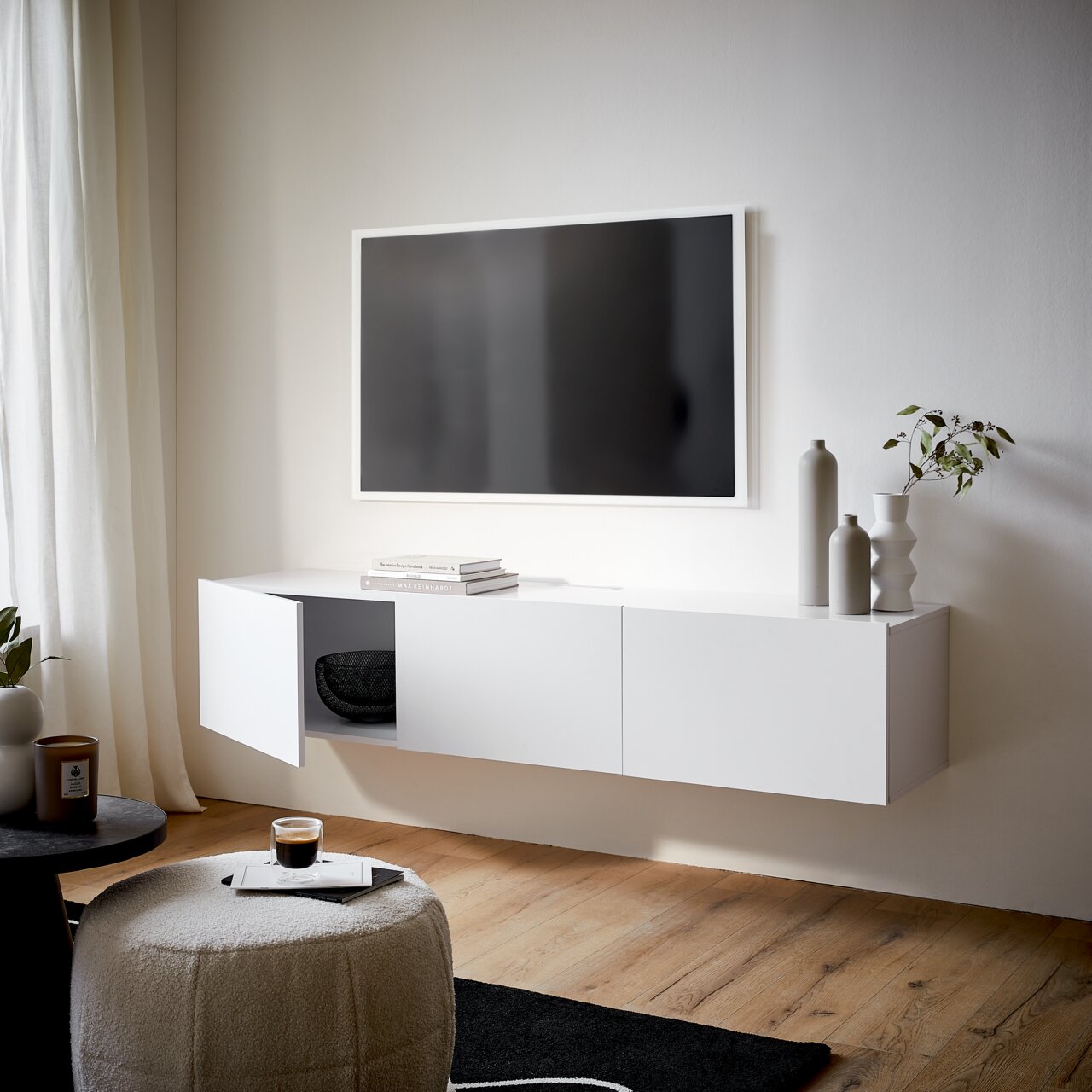 Modernes weißes TV-Hängelowboard in einem stilvollen Wohnzimmer, seitliche Perspektive