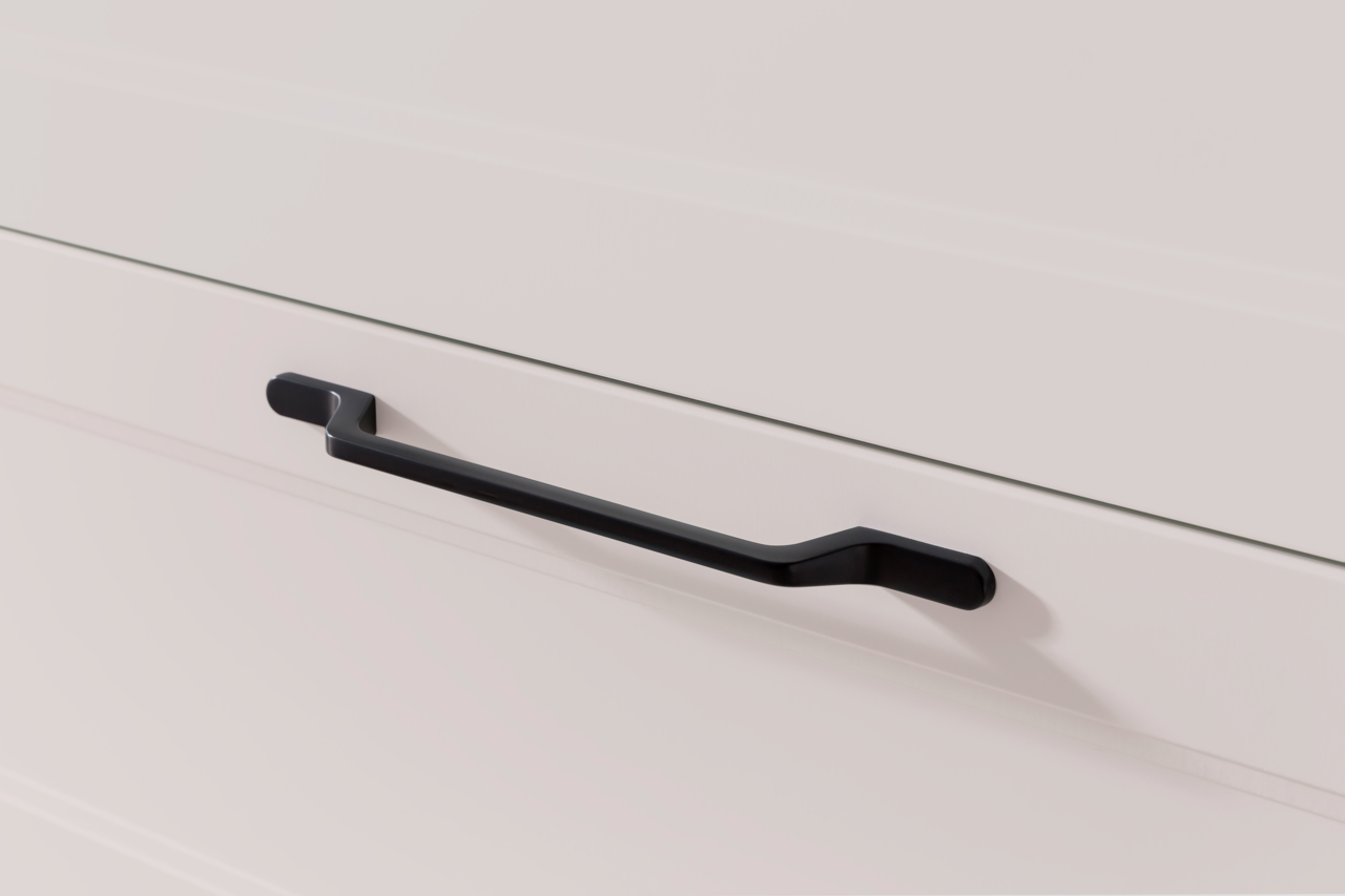 Nahaufnahme eines modernen, schwarzen Griffs an einem weißen Waschtisch, seitliche Perspektive