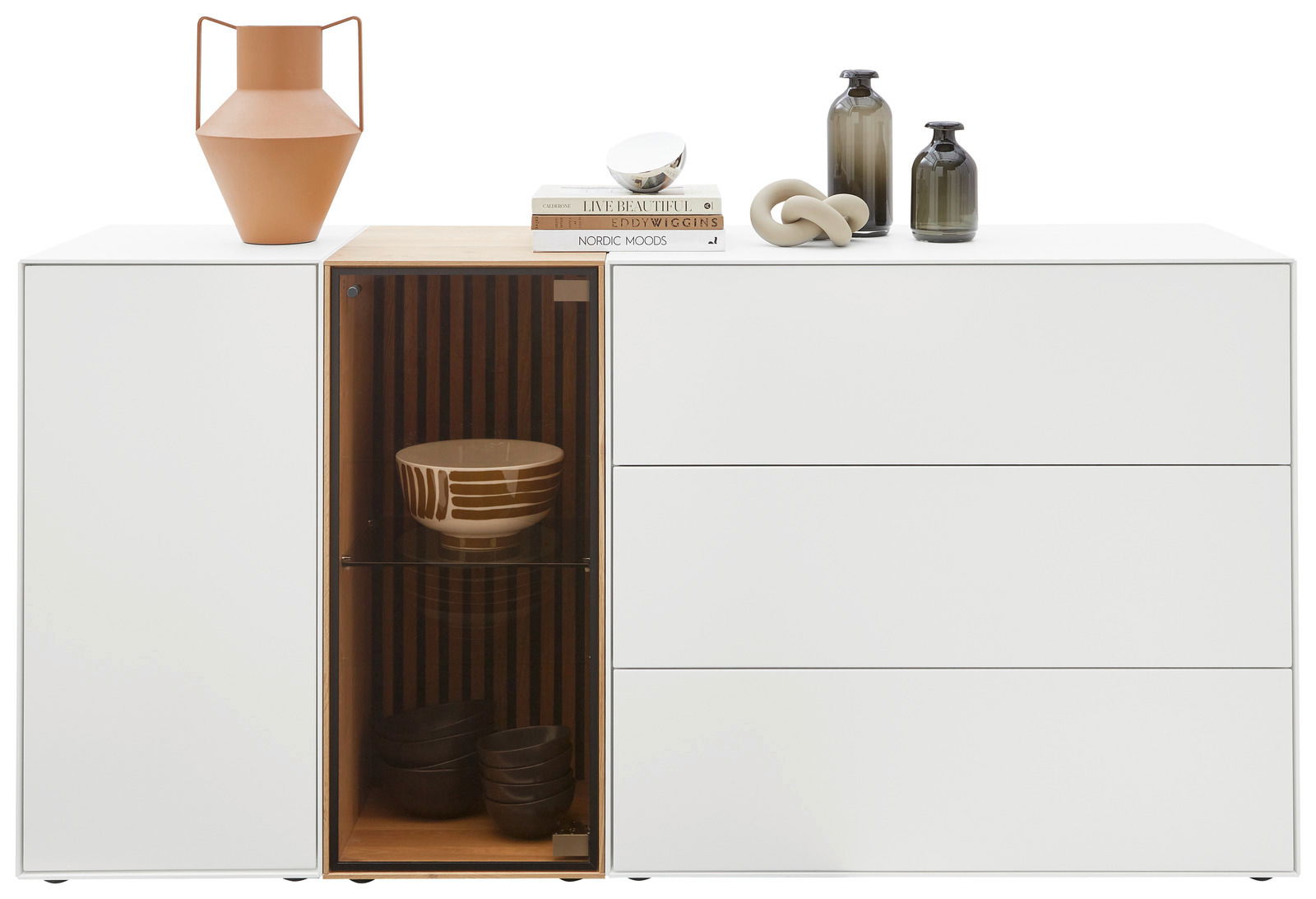 Modernes Sideboard mit Glasvitrine links, dekoriert mit Keramikvasen und Büchern, Frontalansicht