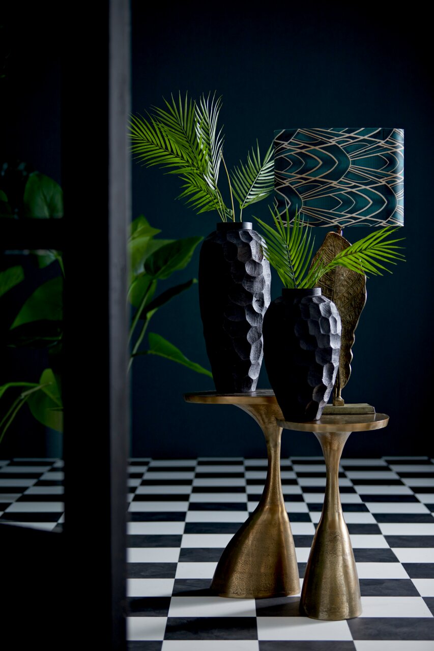 Light&Living Beistelltisch MACAU Beistelltisch aus Metall mit goldener Oberfläche, darauf stehen zwei schwarze Vasen mit Blattmuster und eine Tischlampe, seitliche Perspektive.