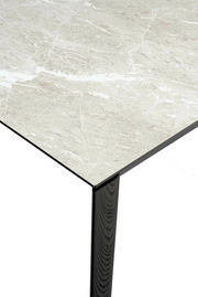 Nahaufnahme eines Connubia Esstisches BAND mit einer eleganten, marmorierten Tischplatte und einem schwarzen Tischbein, aus der Vogelperspektive.
