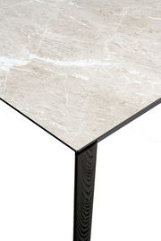 Nahaufnahme eines Connubia Esstisches BAND mit einer eleganten, marmorierten Tischplatte und einem schwarzen Tischbein, aus der Vogelperspektive.