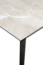 Nahaufnahme eines Connubia Esstisches BAND mit einer eleganten, marmorierten Tischplatte und einem schwarzen Tischbein, aus der Vogelperspektive.