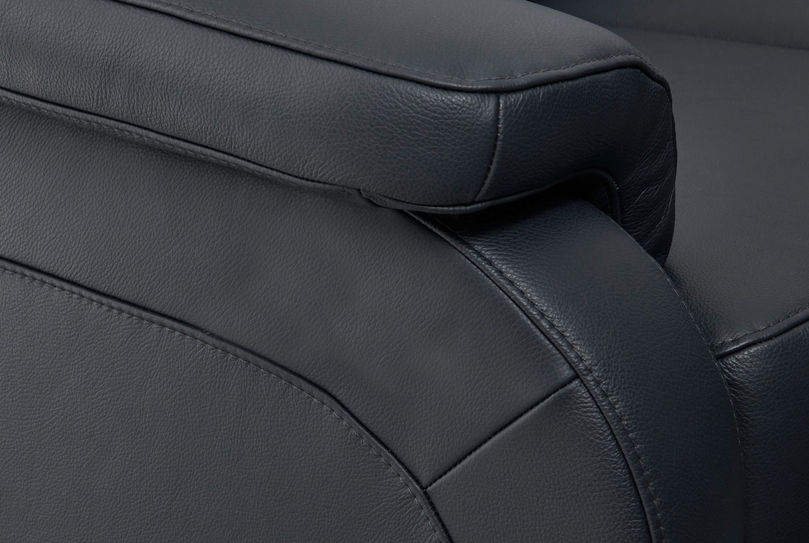 Nahaufnahme einer schwarzen Ledercouch mit Fokus auf die Armlehne und Nahtdetails, seitliche Perspektive.