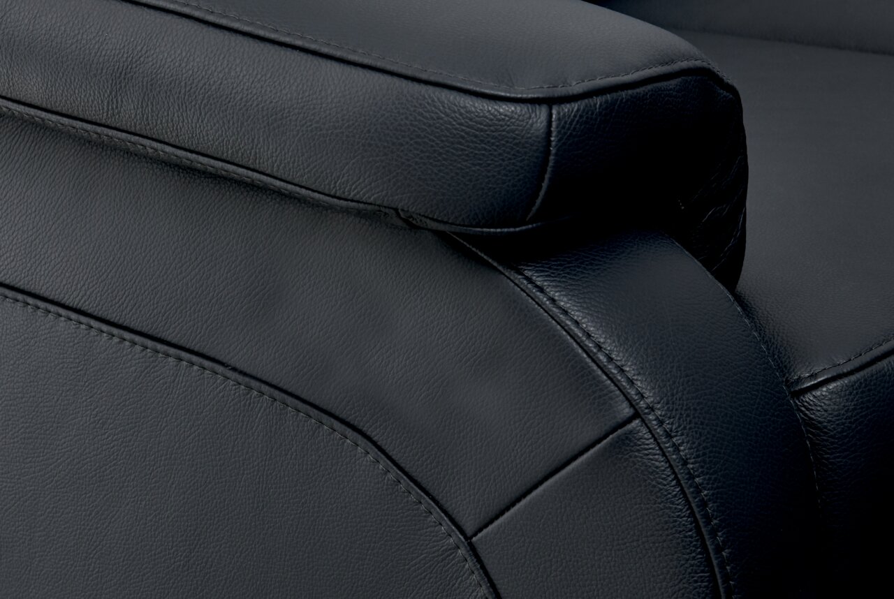 Nahaufnahme einer schwarzen Ledercouch mit Fokus auf die Armlehne und Nahtdetails, seitliche Perspektive.