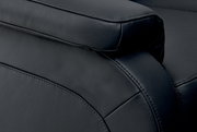 Nahaufnahme einer schwarzen Ledercouch mit Fokus auf die Armlehne und Nahtdetails, seitliche Perspektive.