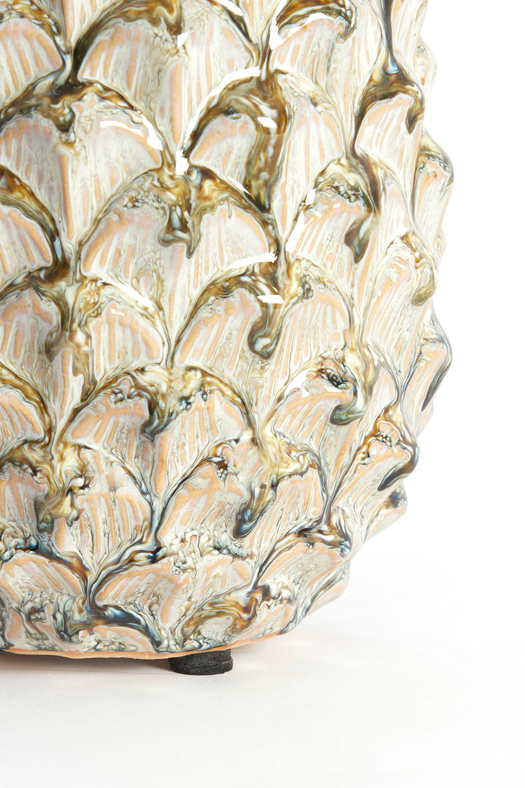 Nahaufnahme eines kunstvoll verzierten Ornaments mit blattähnlichem Muster und glänzender Oberfläche, seitliche Perspektive.