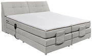 Boxspringbett in hellem Stoffbezug mit verstellbarem Kopfteil, seitlicher Perspektive