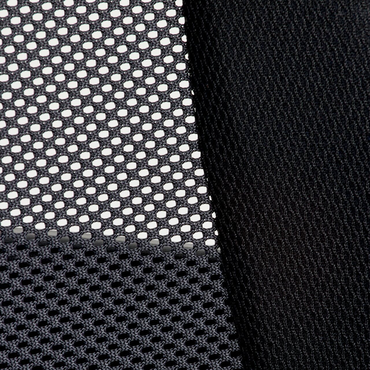 Nahaufnahme eines schwarzen Netzstoffs und eines glatten Stoffes, vermutlich Teil eines Drehstuhls, aus seitlicher Perspektive.