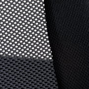 Nahaufnahme eines schwarzen Netzstoffs und eines glatten Stoffes, vermutlich Teil eines Drehstuhls, aus seitlicher Perspektive.