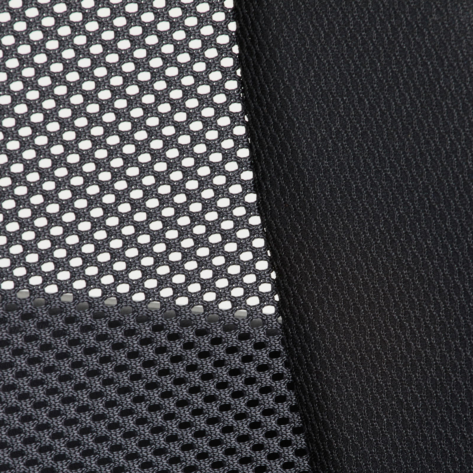 Nahaufnahme eines schwarzen Netzstoffs und eines glatten Stoffes, vermutlich Teil eines Drehstuhls, aus seitlicher Perspektive.