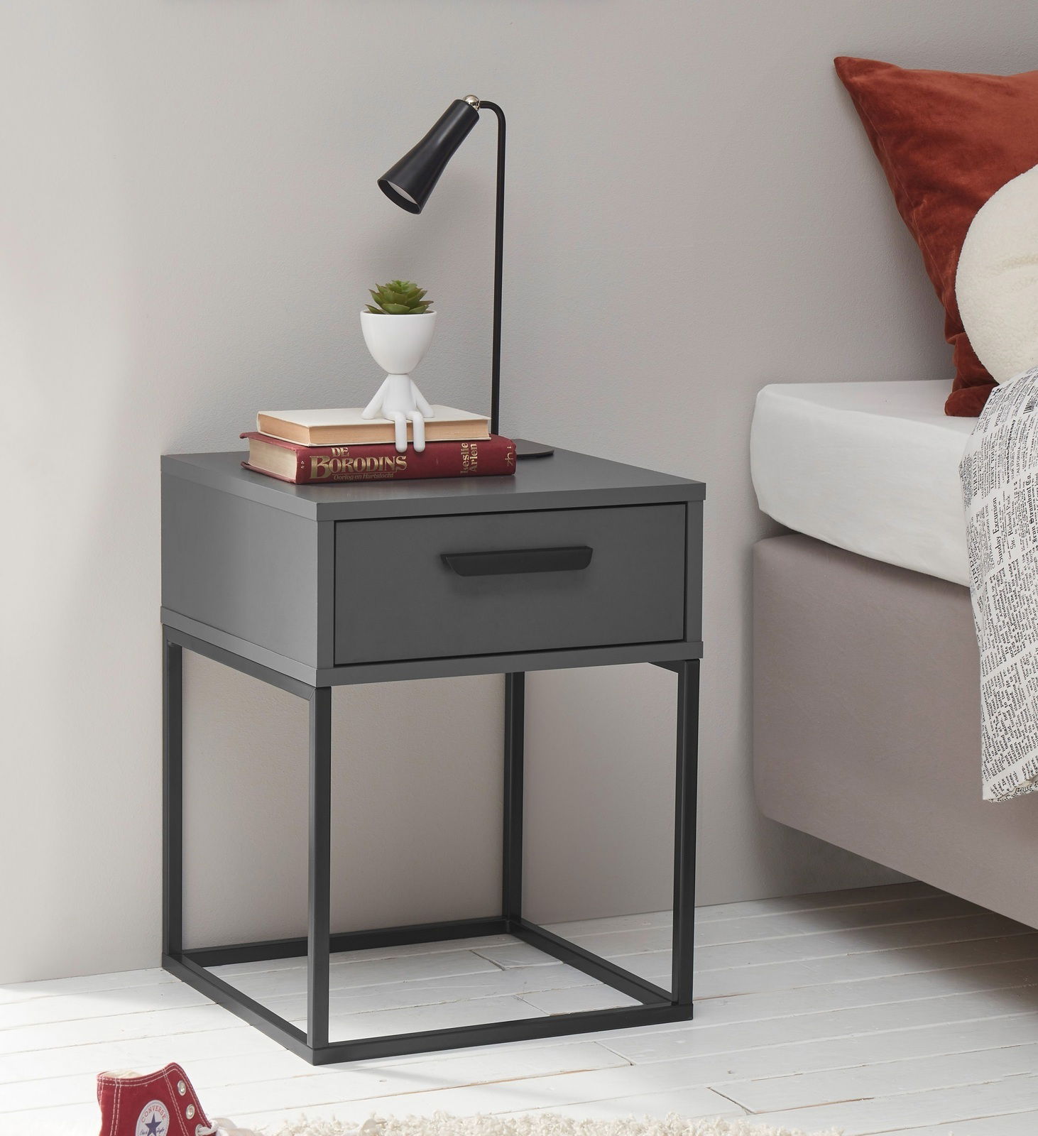 Moderne graue Nachtkommode mit Metallrahmen, einer Schublade und dekorativen Elementen, seitliche Perspektive