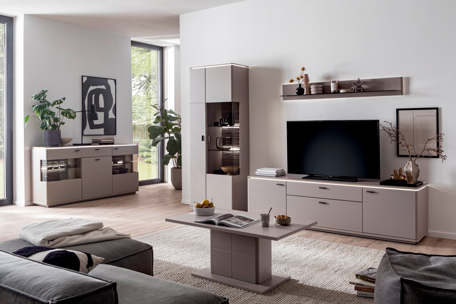 Zurbrüggen Couchtisch TORRENT Modernes Wohnzimmer mit beigefarbener Wohnwand: TV-Lowboard, Vitrine und Sideboard mit Glasfächern und LED-Beleuchtung, dazu passender Couchtisch; Aufnahme aus leicht erhöhter, frontaler Perspektive.