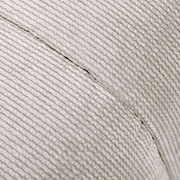 Nahaufnahme eines Hockers mit strukturierter, hellgrauer Stoffoberfläche, seitliche Perspektive