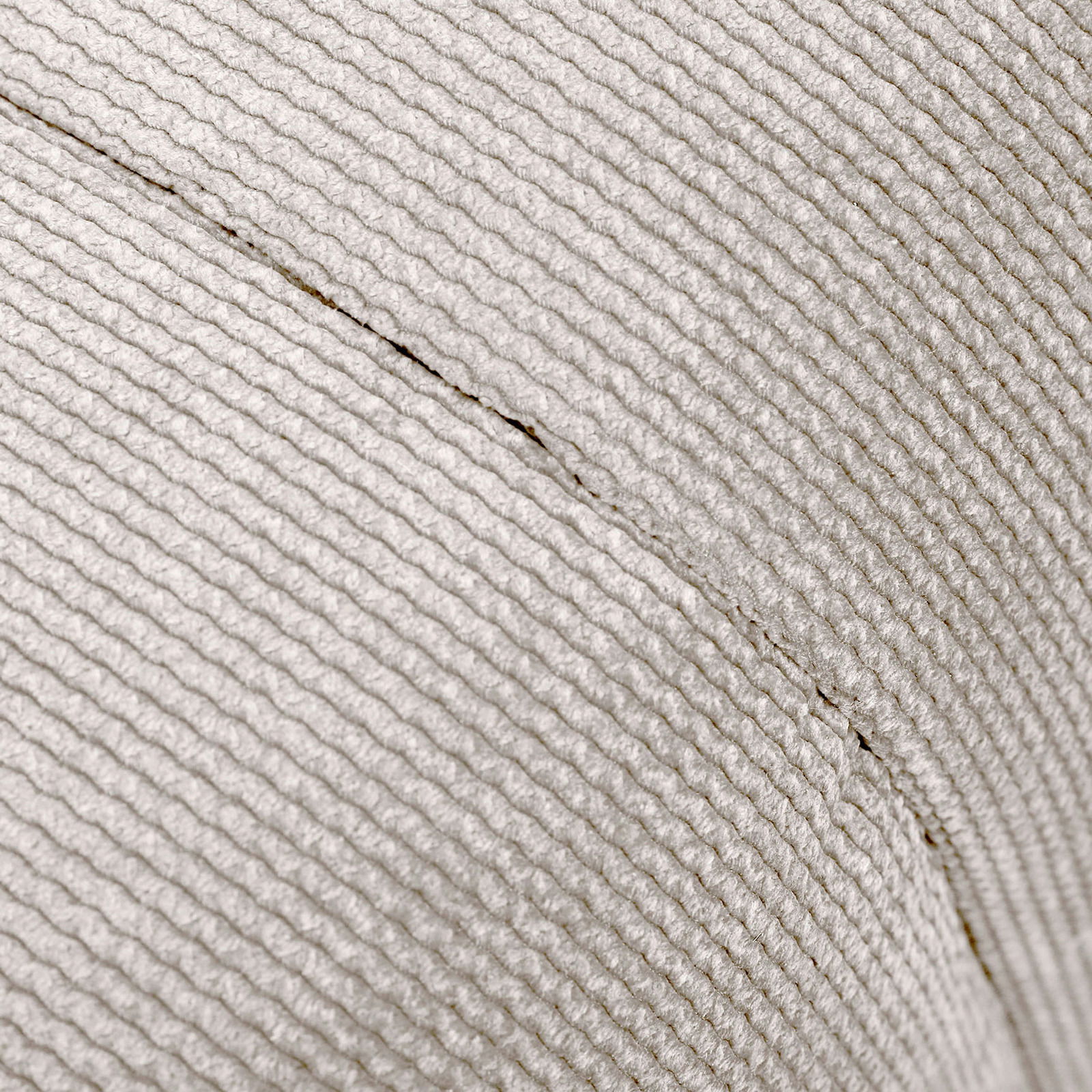 Nahaufnahme eines Hockers mit strukturierter, hellgrauer Stoffoberfläche, seitliche Perspektive