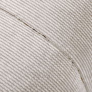 Nahaufnahme eines Hockers mit strukturierter, hellgrauer Stoffoberfläche, seitliche Perspektive