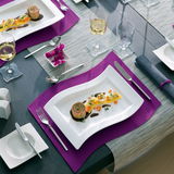 Eleganter Gourmetteller 33x24cm NewWave mit geschwungenem Design, präsentiert in einer stilvollen Tischdekoration von oben.