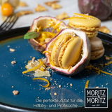 Nahaufnahme eines blauen Desserttellers mit gelben Macarons und Passionsfrucht, dekoriert mit Orangenschalen und Nüssen.
