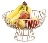 Metallener Obstkorb mit Bananen und Äpfeln, seitliche Perspektive