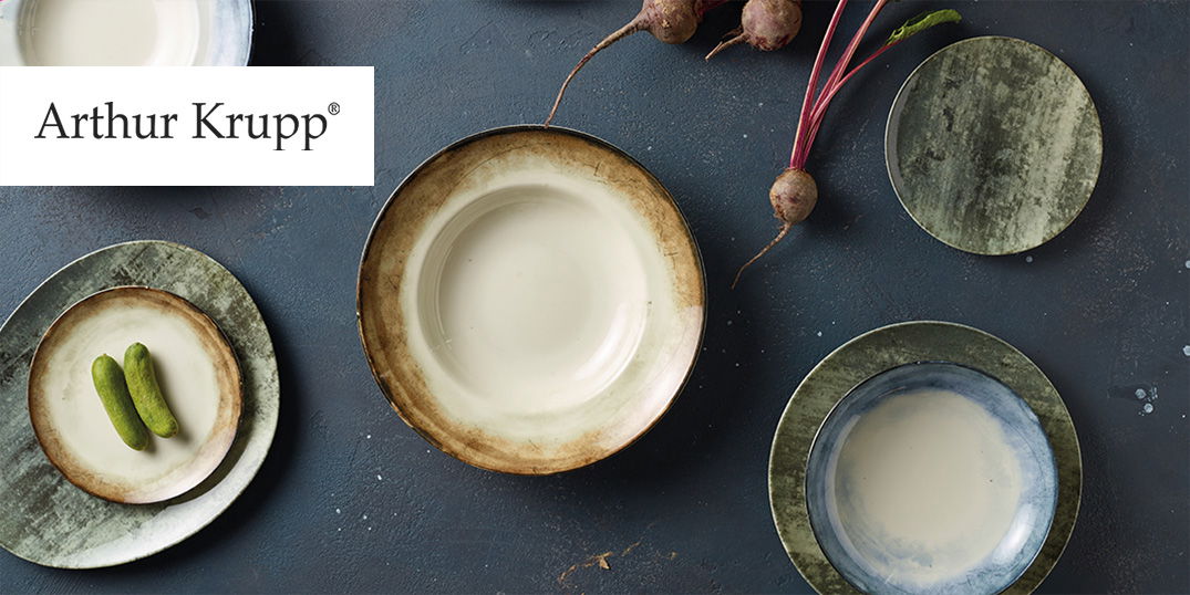 Keramikteller in Erdtönen mit grünen Garnituren und Rüben.