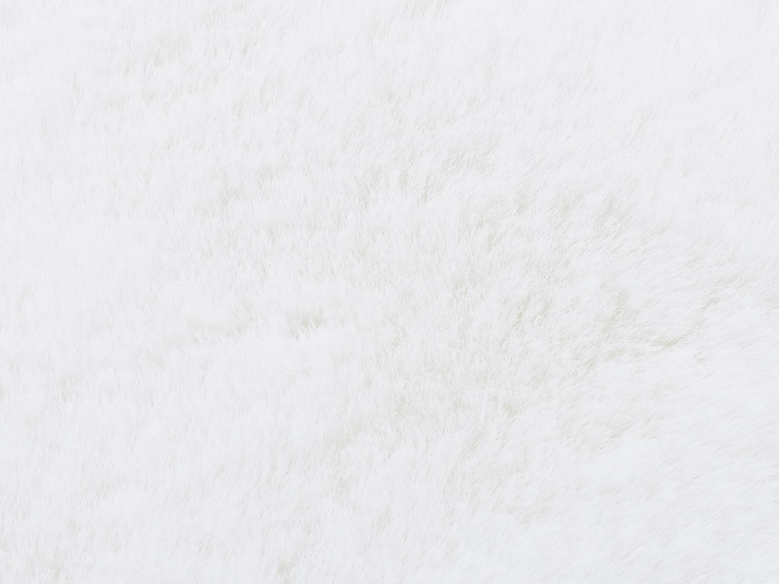 Nahaufnahme eines weißen Fellteppichs mit weicher Textur