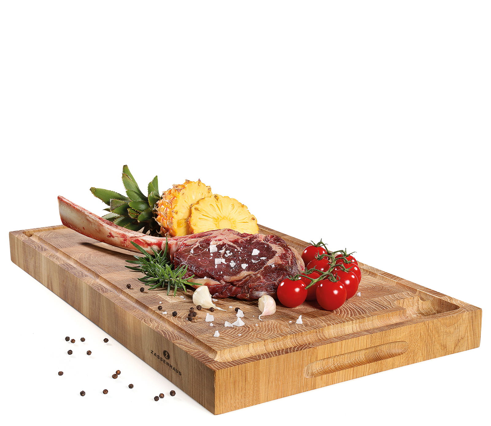 Hackblock aus Eiche Stirnholz mit Tomahawk-Steak, Ananas, Tomaten und Gewürzen, seitliche Perspektive