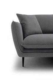 Nahaufnahme eines grauen Stoffsofas mit Armlehne, Sitzkissen und Rückenkissen auf schwarzen, schlanken Füßen, Ansicht schräg von vorne links.